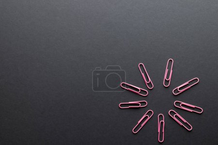 Photo for Close up of pink paper clips in circle and copy space on black background. School materials, organising, learning, school and education concept. - Royalty Free Image