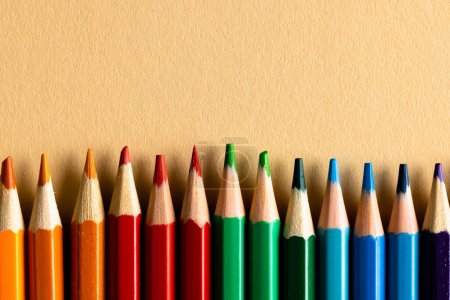 Foto de Primer plano de lápices multicolores y copia el espacio sobre fondo naranja. Concepto de escritura, colorido, aprendizaje, escuela y educación. - Imagen libre de derechos