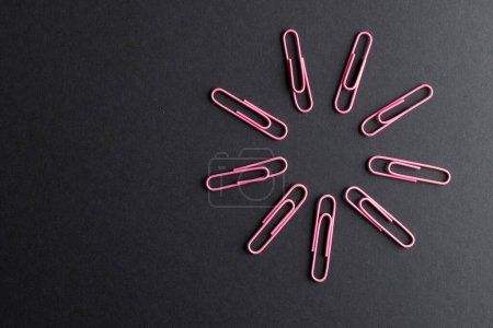 Photo for Close up of pink paper clips in circle and copy space on black background. School materials, organising, learning, school and education concept. - Royalty Free Image