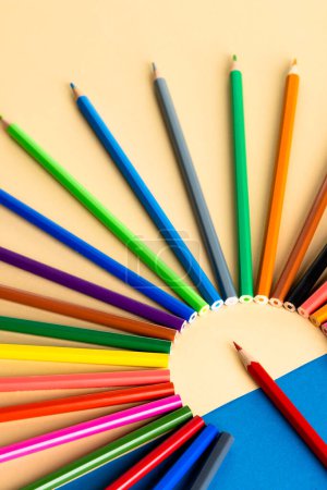 Téléchargez les photos : Gros plan de crayons multicolores en cercle et espace de copie sur fond bleu et jaune. Écriture, coloration, apprentissage, école et éducation concept. - en image libre de droit