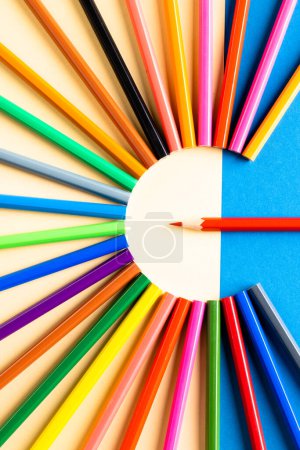 Téléchargez les photos : Gros plan de crayons multicolores en cercle et espace de copie sur fond bleu et jaune. Écriture, coloration, apprentissage, école et éducation concept. - en image libre de droit
