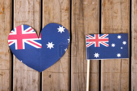 Photo for Overhead view of heart shape with australian flag over wooden table, copy space. National flag, patriotism and identity concept. - Royalty Free Image