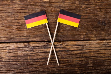 Téléchargez les photos : Vue aérienne de petits drapeaux allemands sur une table en bois, espace de copie. Inchangé, drapeau national, patriotisme et concept d'identité. - en image libre de droit