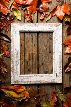 Foto de Vista aérea del antiguo marco vacío con hojas de otoño sobre una mesa de madera. Concepto de temporada inalterado, naturaleza, foto y otoño. - Imagen libre de derechos