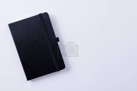 Foto de Primer plano del cuaderno negro con espacio de copia sobre fondo blanco. Literatura, lectura, escritura, tiempo libre y libros. - Imagen libre de derechos