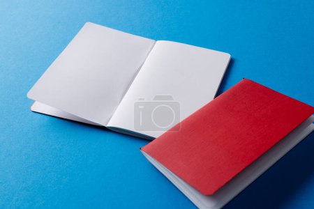 Téléchargez les photos : Gros plan du carnet rouge et du carnet ouvert avec espace de copie sur fond bleu. Littérature, lecture, écriture, loisirs et livres. - en image libre de droit