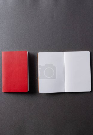 Photo for Close up of red notebook and open book with copy space on grey background. Literature, reading, writing, leisure time and books. - Royalty Free Image