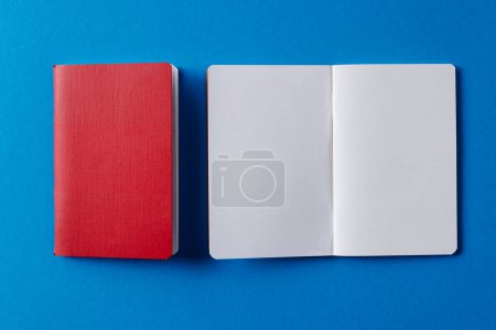Téléchargez les photos : Gros plan du carnet rouge et du carnet ouvert avec espace de copie sur fond bleu. Littérature, lecture, écriture, loisirs et livres. - en image libre de droit