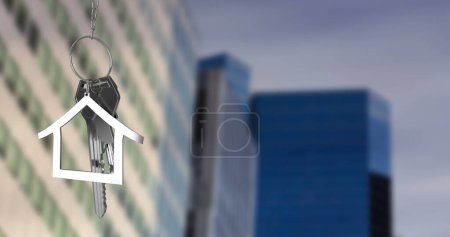 Image of hanging silver house keys against blurred view of tall buildings. Relocation and real estate concept