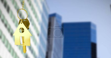 Téléchargez les photos : Image de clés de maison dorées contre vue floue de grands bâtiments. Concept de déménagement et d'immobilier - en image libre de droit