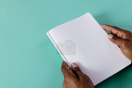 Téléchargez les photos : Mains de l'homme biracial tenant le livre avec l'espace de copie sur fond vert. Littérature, lecture, loisirs et livres. - en image libre de droit