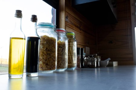 Photo for Storage jars of food on countertop in sunny kitchen in log cabin. Food, nutrition, balanced diet and healthy living. - Royalty Free Image