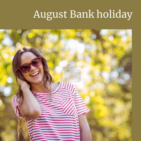Photo for August bank holiday text on green with happy caucasian woman in sunglasses smiling in sun by trees. Campaign celebrating summer, free time and vacations, digitally generated image. - Royalty Free Image