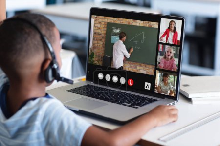Photo for African american boy in headphones listening to teacher teaching over video call on laptop. Unaltered, childhood, technology, education, student, e-learning, online, screen and home concept. - Royalty Free Image