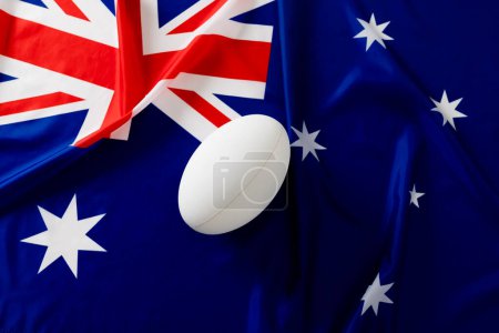 Téléchargez les photos : Ballon de rugby blanc sur le drapeau australien. Rugby, sport, international, compétition et jeux image générée numériquement. - en image libre de droit