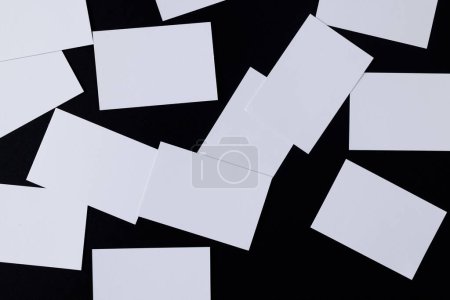 Foto de White business cards with copy space on black background. Business, business card, stationery and writing space digitally generated image. - Imagen libre de derechos