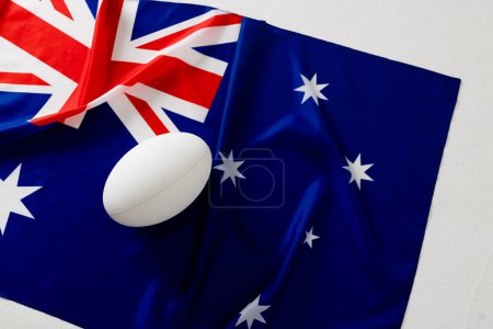 Téléchargez les photos : Ballon de rugby blanc sur le drapeau australien. Rugby, sport, international, compétition et jeux image générée numériquement. - en image libre de droit