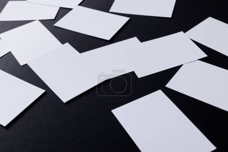 Foto de White business cards with copy space on black background. Business, business card, stationery and writing space digitally generated image. - Imagen libre de derechos