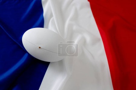 Téléchargez les photos : Balle de rugby blanche au-dessus du drapeau de France. Rugby, sport, international, compétition et jeux image générée numériquement. - en image libre de droit