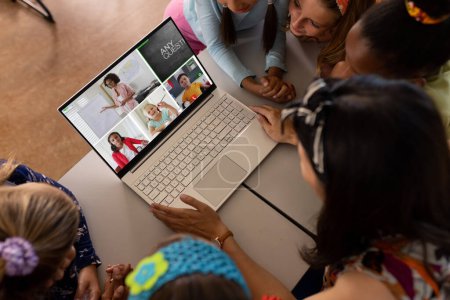 Foto de Profesora asiática y estudiantes diversas que tienen una videoconferencia en la computadora portátil en la escuela. Concepto de educación a distancia en línea - Imagen libre de derechos