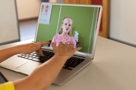 Photo for Mid section of a boy using laptop while having a video call with caucasian girl at home. Distant learning online education concept - Royalty Free Image