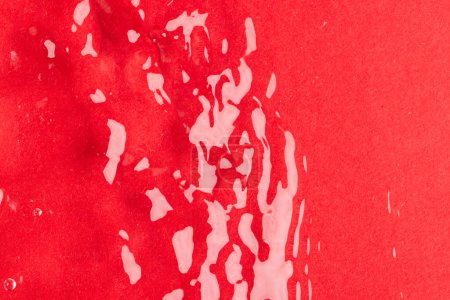 Téléchargez les photos : Gros plan des ondulations d'eau et des vagues avec espace de copie sur fond rouge. Concept eau, liquide et couleur. - en image libre de droit