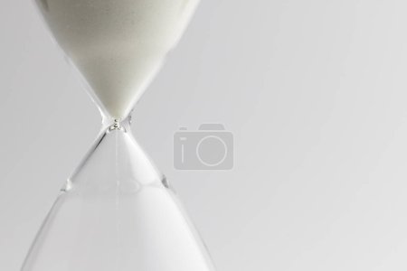 Foto de Primer plano de reloj de arena blanca y espacio de copia sobre fondo blanco. Tiempo, cronometraje, forma y concepto de color. - Imagen libre de derechos