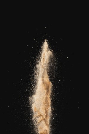 Photo for Close up of sand thrown in the air and copy space on black background. Sand, texture, movement, shape and colour concept. - Royalty Free Image