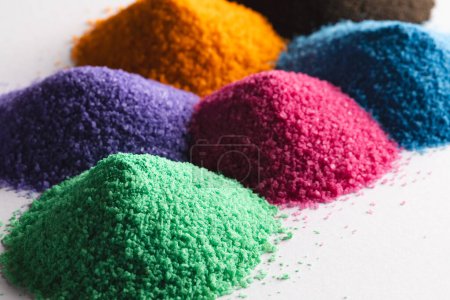 Photo for Close up of heaps of multi coloured sand and copy space on white background. Sand, texture, movement, shape and colour concept. - Royalty Free Image