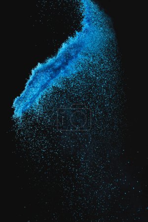 Photo for Close up of blue sand thrown in the air and copy space on black background. Sand, texture, movement, shape and colour concept. - Royalty Free Image