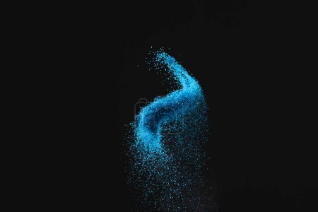 Photo for Close up of blue sand thrown in the air and copy space on black background. Time, timekeeping, shape and colour concept. - Royalty Free Image