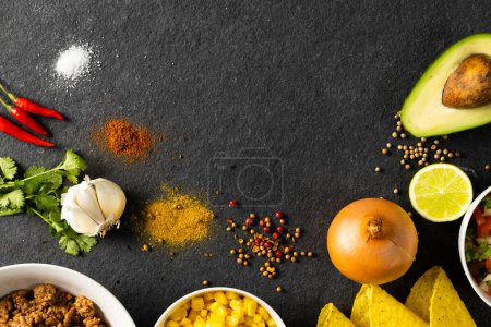 Photo for Directly above shot of various spices with avocado, tortillas, onion, lemon and meat on table. unaltered, taco, corn, ingredients, food, preparation and mexican food concept. - Royalty Free Image