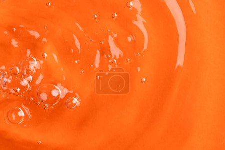 Foto de Primer plano de burbujas de aire, ondulaciones de agua y olas con espacio para copiar sobre fondo naranja. Concepto de agua, líquido y color. - Imagen libre de derechos