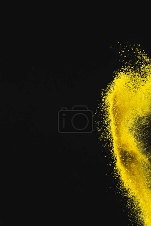 Photo for Close up of yellow sand thrown in the air and copy space on black background. Time, timekeeping, shape and colour concept. - Royalty Free Image