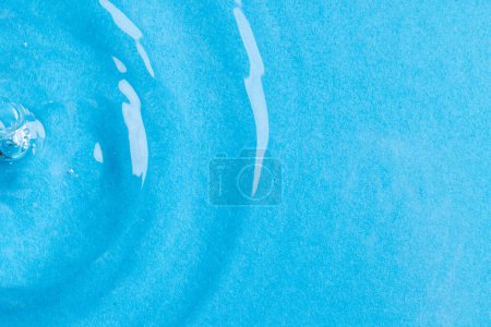 Téléchargez les photos : Gros plan d'eau avec des vagues et des ondulations et copier l'espace sur fond bleu. Concept eau, forme, liquide et couleur. - en image libre de droit