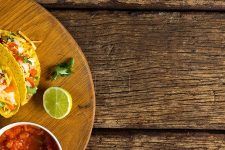 Téléchargez les photos : Directement au-dessus de la photo de tacos au citron, à la coriandre et à la sauce dans un bol au-dessus de la table. bois, inaltéré, garniture, tortilla, nourriture, concept alimentaire frais et mexicain. - en image libre de droit