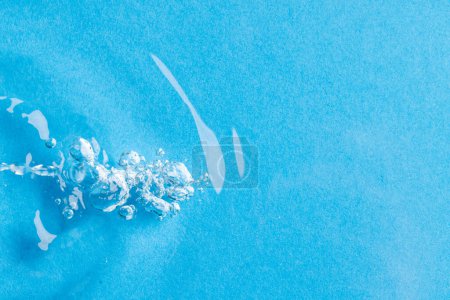 Foto de Primer plano de burbujas de aire, ondulaciones de agua y olas con espacio para copiar sobre fondo azul. Concepto de agua, líquido y color. - Imagen libre de derechos