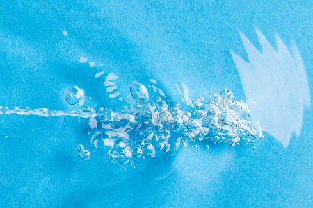 Foto de Primer plano de burbujas de aire, ondulaciones de agua y olas con espacio para copiar sobre fondo azul. Concepto de agua, líquido y color. - Imagen libre de derechos