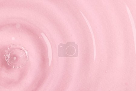 Photo for Close up of water drop falling into water with ripples and copy space on pink background. Water, liquid and colour concept. - Royalty Free Image