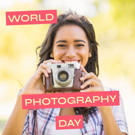 Photo for World photography day text on red over happy biracial woman holding outdoors in sun. Global celebration of photography campaign, digitally generated image. - Royalty Free Image
