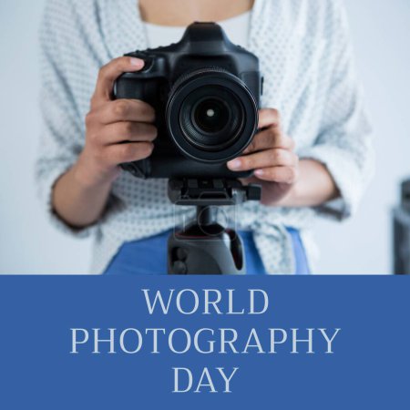 Téléchargez les photos : Journée mondiale de la photographie texte sur le bleu au-dessus du milieu de la femme biraciale en utilisant un appareil photo sur trépied. Célébration mondiale de la campagne photographique, image générée numériquement. - en image libre de droit