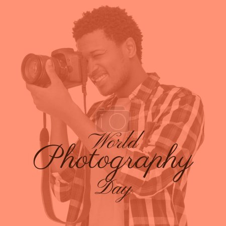 Photo for World photography day text on orange with happy african american man using camera. Global celebration of photography campaign, digitally generated image. - Royalty Free Image