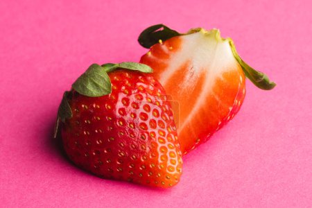 Photo for Close up of halved strawberry and copy space on pink background. Fruit, berry, food, freshness and colour concept. - Royalty Free Image