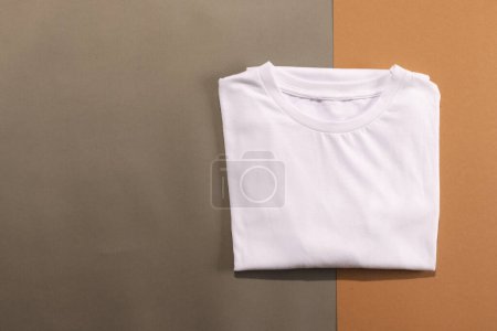 Foto de Primer plano de camisetas blancas dobladas y espacio de copia sobre fondo marrón. Moda, ropa, color y concepto de tela. - Imagen libre de derechos
