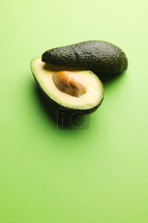 Photo for Close up of two halves of avocado and copy space on green background. Vegetable, food, freshness and colour concept. - Royalty Free Image