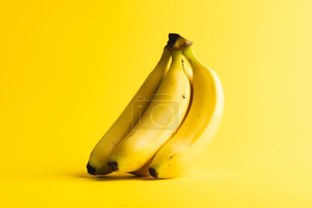 Foto de Cierre de plátanos y espacio de copia sobre fondo amarillo. Frutas, frutas exóticas, alimentos, frescura y concepto de color. - Imagen libre de derechos