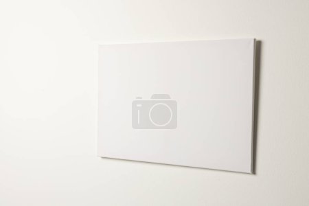 Photo for White canvas and copy space hanging in white wall background. Signage, writing space and advertising concept. - Royalty Free Image