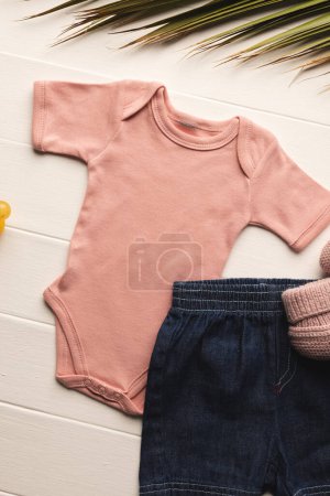 Photo for Flat lay of pink baby grow, shorts, dummy and pink booties with copy space on white background. Baby fashion, clothes, colour and fabric concept. - Royalty Free Image