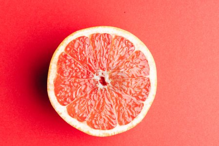 Photo for Close up of half of red grapefruit and copy space on red background. Fruit, food, freshness and colour concept. - Royalty Free Image