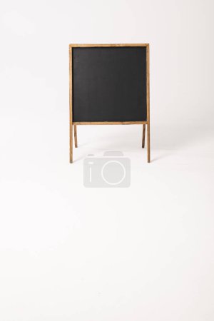 Foto de Cartel negro en marco de madera y espacio para copiar sobre fondo blanco. Señalización, espacio de escritura y concepto publicitario. - Imagen libre de derechos